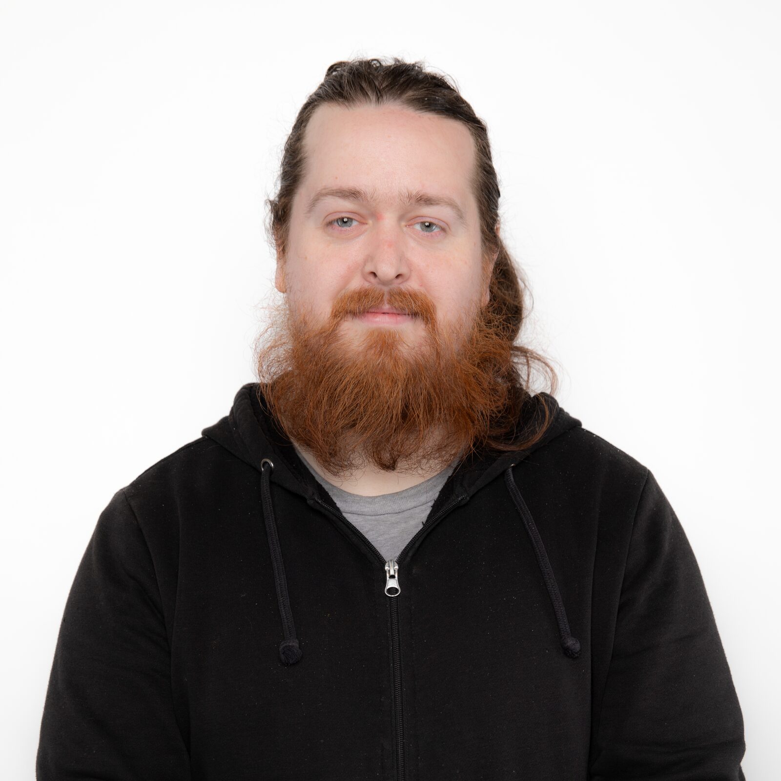 Gabriel Leger, with a long red beard, in a black zip-up hoodie