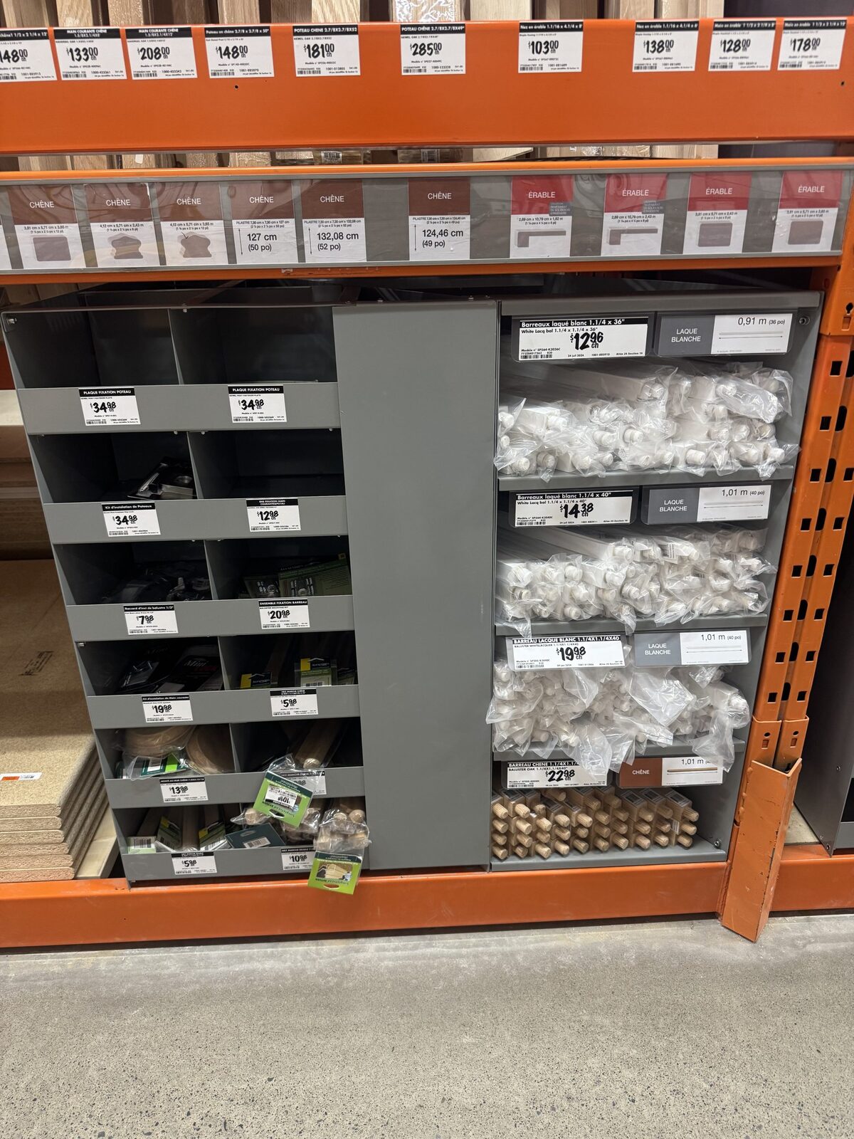 Close view of the compartments, with bagged stair hardware and a price label on every opening