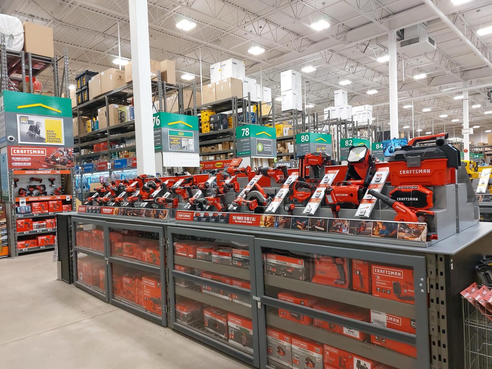 Craftsman cordless tools ranged along the display deck above locked glass-front cabinets in a Kent store